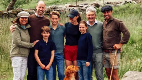 Instagram/princeandprincessofwales Catherine in the middle, next to her dad and son, husband, mum, brother and two other children. A golden retriever sits at their feet 