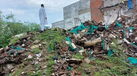 Afreen Fatima Javed Mohammad stands on top of the debris and stares at where his house used to be before it was demolished in the Indian state of Uttar Pradesh. 