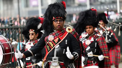 Reuters Members of Shree Muktajeevan Swamibapa Pipe Band perform while wearing tartan kilts.