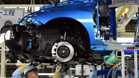 AFP A man works on a Toyota Mirai vehicle on the production line