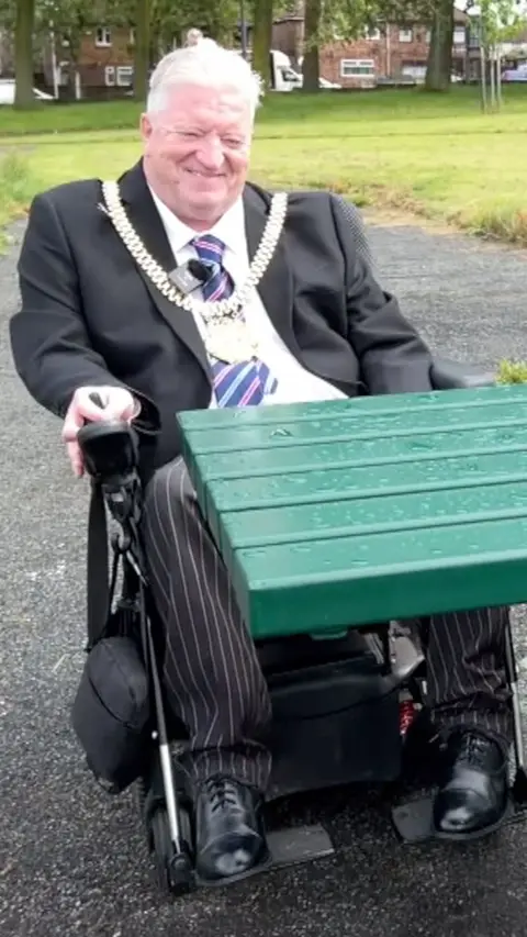 Lord Mayor in front of a accesible green park bench