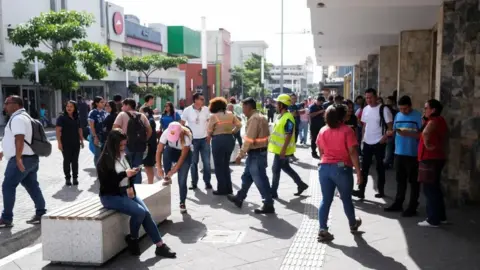 People pictured in a street in San Salvador, El Salvador's capital, following an evacuation