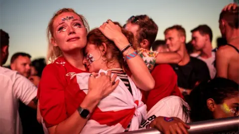 Getty Images Fans console each other at London's Hyde Park