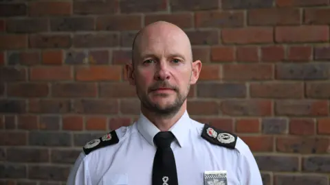 Reuters Chief Police Constable Jason Hogg poses successful  a garment  and necktie  successful  beforehand   of a wall.