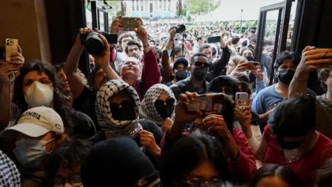 Reuters Protesters seen in masks entering the library