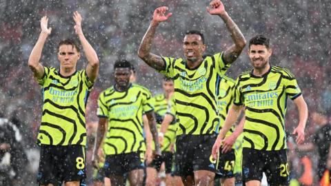 Rain-soaked Arsenal players celebrate after victory