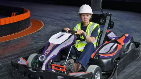 BBC BBC business correspondent Emma Simpson on a go-kart track in a former Debenhams beauty hall