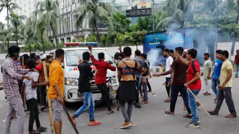 Reuters Demonstrators stop an ambulance to check whether there are any patients inside before allowing it to leave during a protest demanding the stepping down of Bangladeshi Prime Minister Sheikh Hasina, following quota reform protests by students, in Dhaka, Bangladesh, August 4, 2024