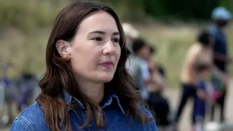Tennis player Kimberly Schreiber, who has long brown hair and wears a blue denim shirt