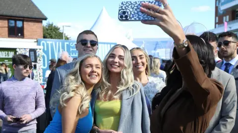 PA Media Woman takes picture at Aintree