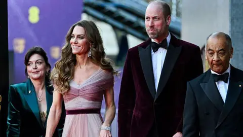 AFP via Getty Images Kate and William walk along smiling next to two people
