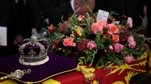 Reuters A handwritten card on top of the Queen's coffin reads: "In loving and devoted memory. Charles R".