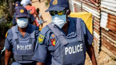 Getty Images Two police officers wearing masks