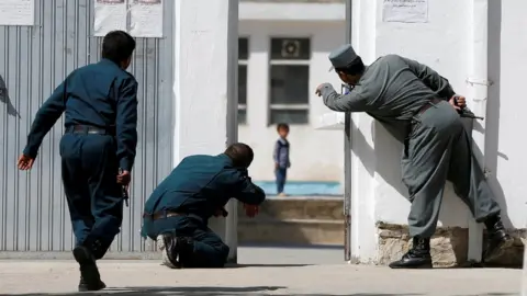 Reuters Afghan policemen try to rescue a child at the site of a suicide attack at a mosque in Kabul, Afghanistan, August 25, 2017.
