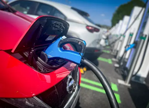 Getty Images Red car being charged