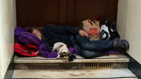 BBC Man asleep in doorway with dog