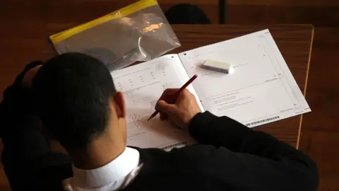 PA Media A student taking a GCSE exam