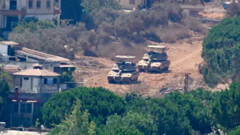 EPA Israeli tanks in Zawtar al-Sharqiyeh, as seen from Zawtar al-Gharbiyeh, southern Lebanon (5 August 2026)