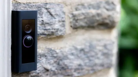 Getty Images A close up of a black doorbell camera on a light-coloured stone wall.