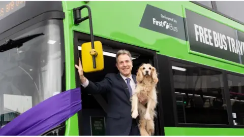 WECA Dan Norris holding his dog Angel on a Green bus