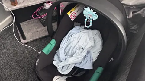 West Yorkshire Police A black and grey baby's car seat with a blue blanket on it