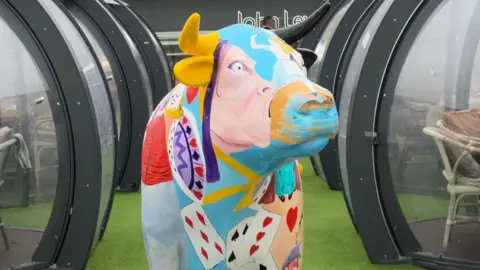 Alice Ox is an ox art sculpture which has been painted for charity in the theme of the Lewis Carroll book Alice's Adventures in Wonderland, which was written in the city.