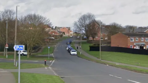 An undulating road leading into a housing estate