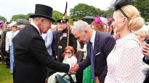 PA Media Graeme Souness shaking hands with the King and bowing.