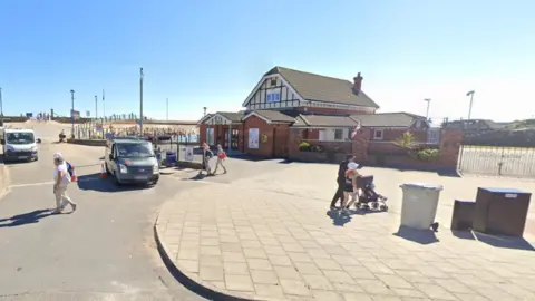 Google Google view of the Meridale centre with people walking past in the foreground. The building is situated close to the seafront.