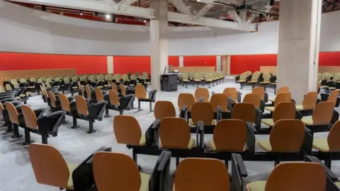TQEC A view of an auditorium with seats arranged in a circle facing the middle of the room.
