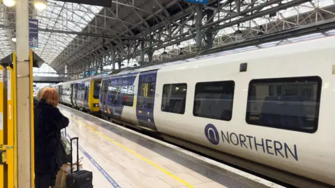 Getty Images Northern train after arriving at Manchester Piccadilly railway station in a white and blue livery