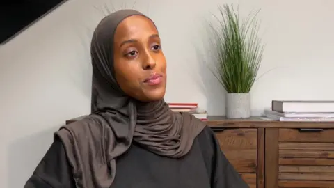 BBC Iqra Ismail, dressed in a dark T-shirt and headscarf, talks to the BBC about the tracksuit bottom problem.