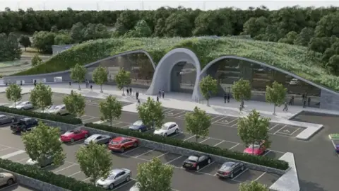 Roadchef/planning documents Proposed plans (artist impression) for a new services near the A1(M) at Boroughbridge in North Yorkshire, with several cars parked outside a building which has a green roof. Trees and hedges separate the cars. 