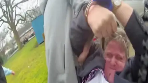 Norfolk Constabulary A red-faced Hill struggles with officers as he is arrested