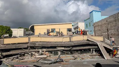 Getty Images Rescue workers are seen at the site of a collapsed building after a powerful earthquake struck Port Vila, the capital of Vanuatu, on December 17, 2024.