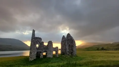 Kerstin Altes Sunset image of the ruins of a castle on the edge of Loch Assynt