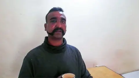 AFP In this handout photograph released by Pakistan"s Inter Services Public Relations (ISPR) on February 27, 2019, shows captured Indian pilot looking on as holding a cup of tea in the custody of Pakistani forces in an undisclosed location