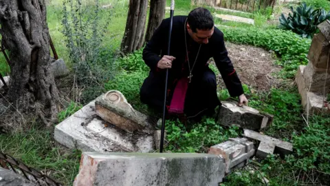 Reuters A vandalised tombstone at the Protestant Mount Zion Cemetery