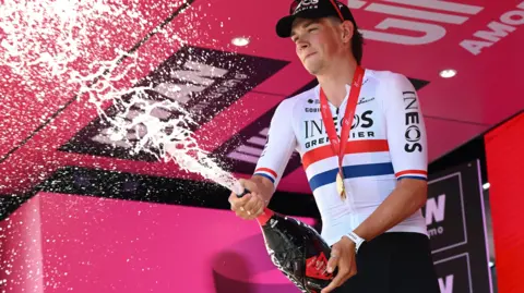 Ineos Grenadiers rider Josh Tarling sprays champagne after winning stage two of the 2025 Giro d'Italia
