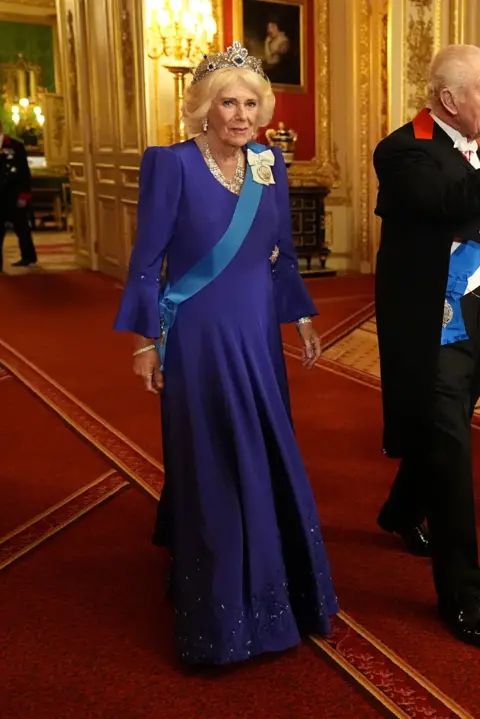 Aaron Chown/REUTERS Queen Camilla wearing a royal blue silk marocain embroidered dress by Fiona Clare, and a sapphire and diamond tiara, and the King's Family Order.