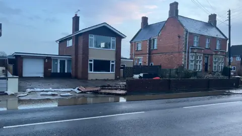 A house in the early hours with flooding on the pavement in front of it