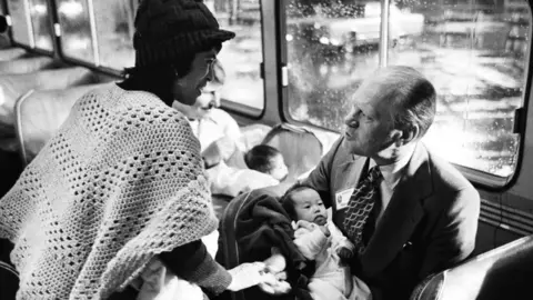 Getty Images Presiden Gerald Ford menggendong anak-anak Viet saat mereka tiba di Amerika Serikat