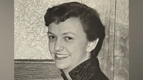 Family photo A black and white photo of Sheila as a younger woman with short dark hair and a high collared jacket.