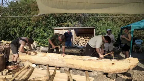 Rockingham Forest Trust Six volunteers working on or discussing a log boat, Stanwick Lakes