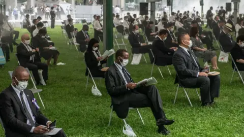 Getty Images People sit in socially distanced chairs as a precaution against coronavirus as they as they attend the 75th anniversary of the Hiroshima atomic bombing,