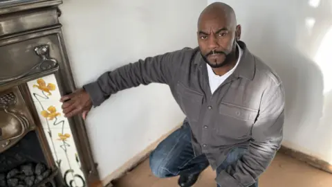 Andy Palmer Andy Palmer beside his fireplace