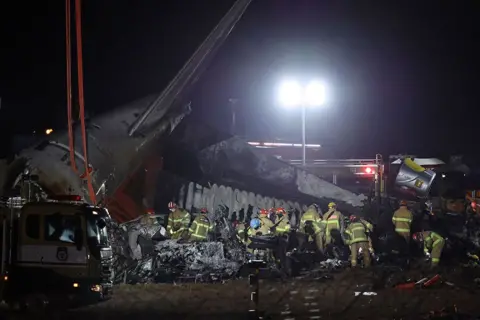 HAN MYUNG-GU/EPA Firefighters work near the wreckage of a Jeju Air aircraft at Muan International Airport in Muan, South Jeolla province, South Korea, 29 December 2024. 