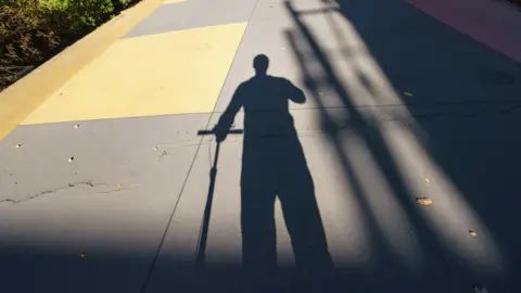 Getty Images Man on scooter in silhouette