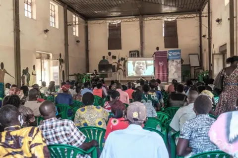 AFP People watch the verdict in Gulu.