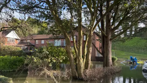 Outside Casterbridge Lodge on Saturday morning. The pump is seen close to the building and there is a car in the water nearby.